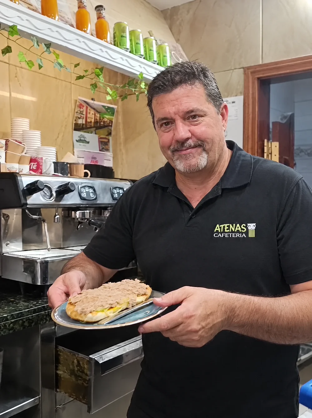 Javier sirviendo una tostada en la barra de Atenas Cafetería
